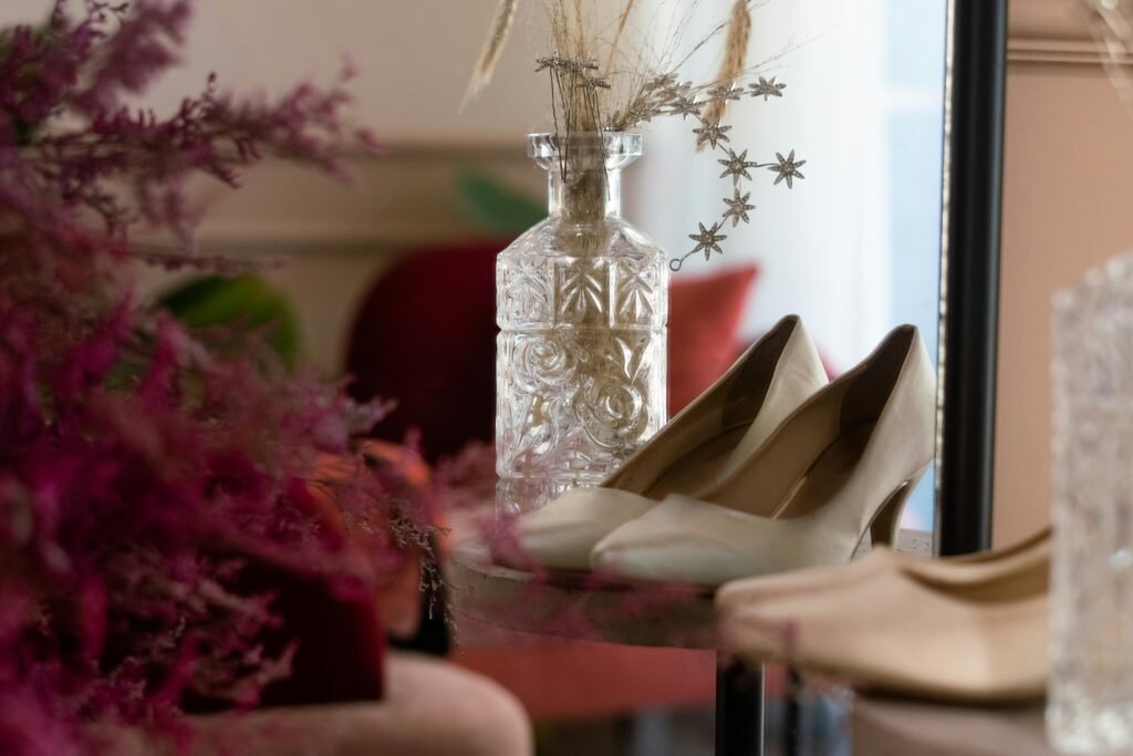 Elegant high heel shoes paired with a crystal vase and decorative flowers, capturing a stylish and classic look.